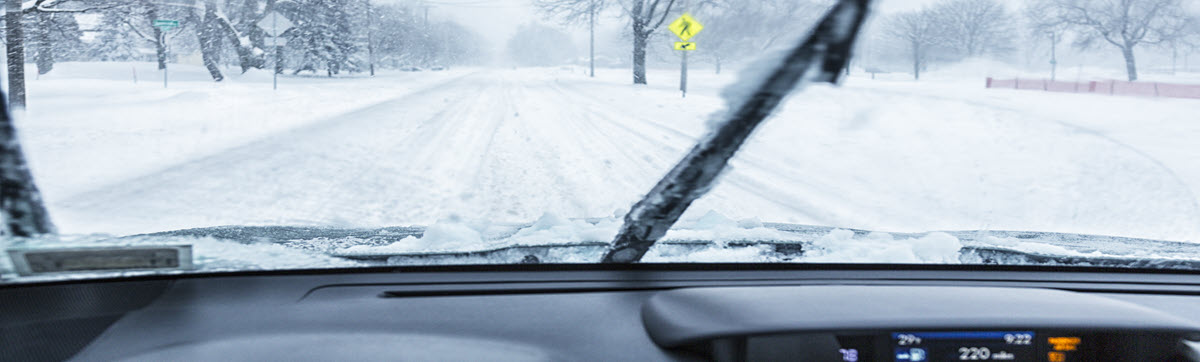 photo of car driving on snow covered road