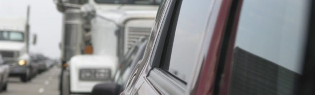 photo of large truck behind a passenger vehicle