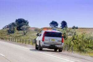 state trooper on road side with lights flashing