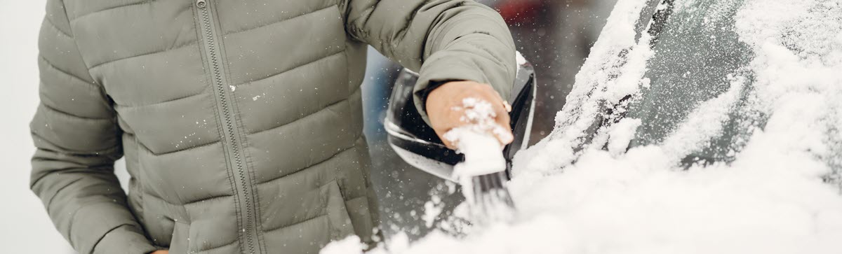 woman clearing snow off a car