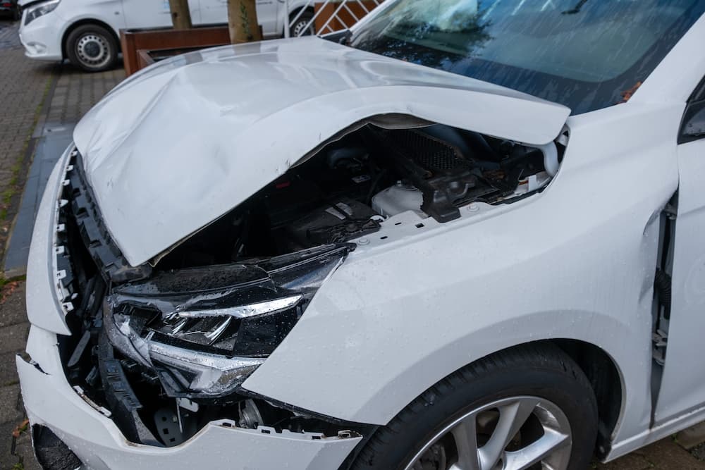 wrecked white sedan to show importance of personal injury medical record for Flager Law